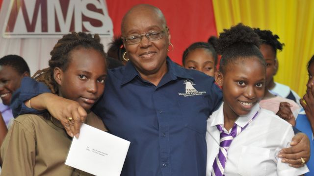 Chairman and CEO of Manpower and Maintenance Services Limited (MMS), Audrey Hinchcliffe (centre), is happy to be flanked by GSAT awardees Ajani Whyte (left) who is headed to St. George’s College and Mercedes Watson who is bound for Campion College as they all smile for the camera during a function organized by MMS to honour 34 of the children of staff members who completed the GSAT examinations earlier this year. The students received bursaries from the Manpower Foundation, gift certificates to start their own accounts from First Heritage Cooperative Credit Union; as well as supplies and other tokens from Lasco distributors, the Guardian Group, Grace Foods, Hi-Lo Food Stores, and PriceSmart at MMS’ annual GSAT Awards ceremony held at the Company’s headquarters in Kingston on Friday, August 24.