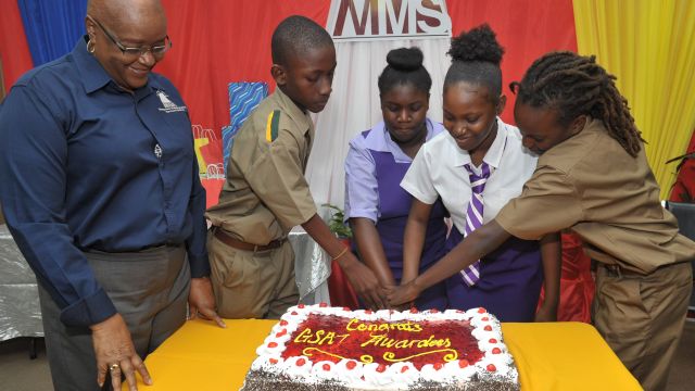 Chairman and CEO of Manpower and Maintenance Services Limited (MMS), Audrey Hinchcliffe (left), joins in cutting the celebratory cake with some of the children of the Company’s staff who recently completed the GSAT examinations and will be heading to high school in September. Seen with her are (L-R) Jusus Bowers who will be attending St. Jago High School, Taylor-Ann Stewart who has a place at Bishop Gibson High, Mercedes Watson who is bound for Campion College and Ajani Whyte who will be a student at St. George’s College. MMS feted 34 students at a function held in their honour at the Company’s headquarters in Kingston on Friday, August 24.