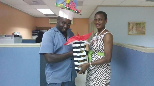 Devon Howe ; Grounds Supervisor (Left) receives his prize from Monica Young; Director- Human Resource Management & Allied Services, for the best hat on Hat Day 2018