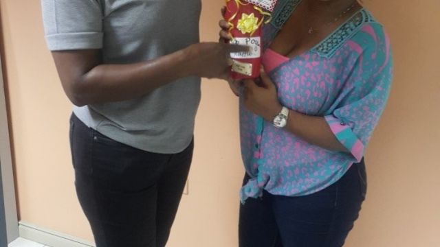 Lavern Stewart; Roving Supervisor (left) receives her prize from Shari Reid; HR Admin Asst (right) had the lucky number that made her the Sip Sip Pour Raffle Winner